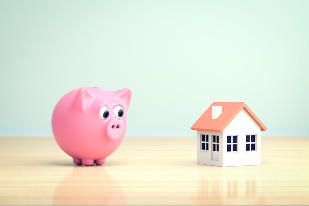 pink piggy bank staring at a home