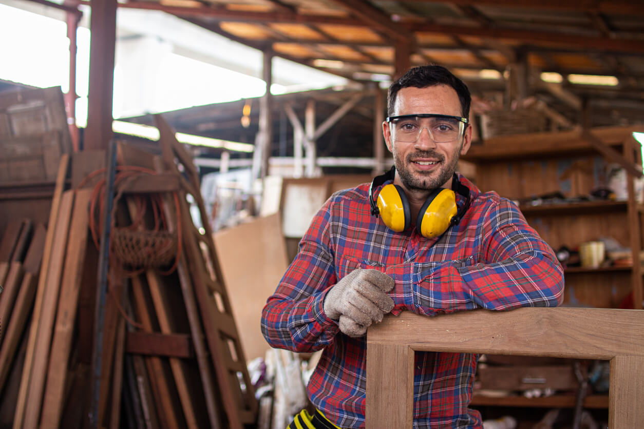 A photo of a man standing in a woodshop, looking at the camera.